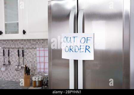 Written Text Out Of Order Message On Paper Over The Stuck Closed Refrigerator In Kitchen Stock Photo