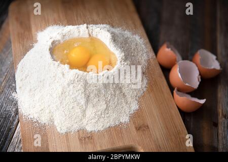 Two eggs in flour with egg shells on the side. Stock Photo