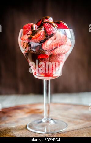 Fresh strawberries under chocolate topping in the glass Stock Photo