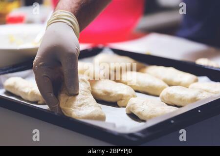 Chef working with dough in bakery. Cooking fancy bread, making delicious pastry on homemade recipe Stock Photo