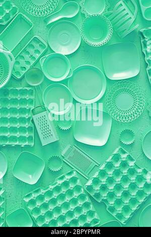 Close up flat lay of different teal blue color painted kitchen utensils and tools, grater, spoon, egg carton, plastic disposable plates, elevated top Stock Photo