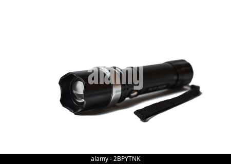 Portable black flashlight isolated on a white background. Flashlight with variable optical focus. Made of aluminum. Stock Photo
