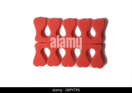 Toe separator isolated on a white background. Pair of toe separator in the form of small hearts. Spongy material. Stock Photo