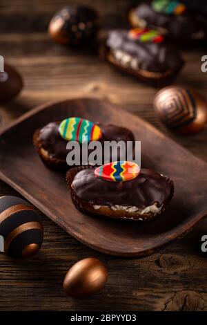 Chocolate glazed cake decorated with colorful chocolate egg Stock Photo