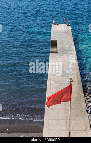 Two fishermen on the pier during phase one of de-escalation of the Covid 19, coronavirus, Playa de Ajabo, Callao Salvaje, State of Emergency, Costa Ad Stock Photo