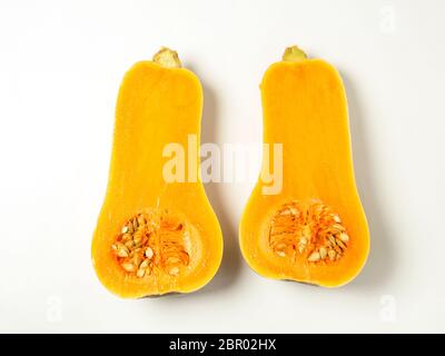 Two halves of a butternut squash with seeds isolated on a white background Stock Photo