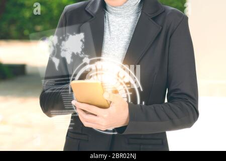 Business woman using mobile phone on her hand with virtual screen which display the interface of world maps and binary code. Digital technology concep Stock Photo