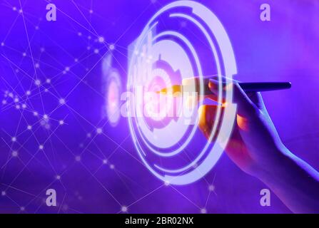 Business hand with markers touching a circle on virtual screen which display the interface of graphs and business network. Digital technology concept Stock Photo