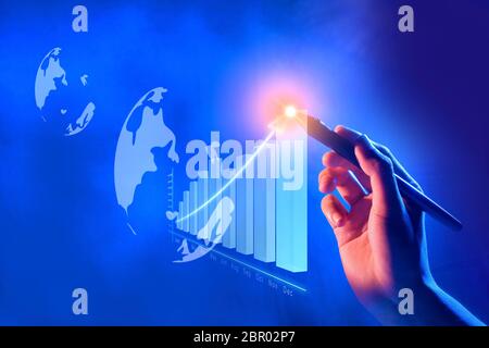 Business hand with marker draw a increases financial chart on virtual screen which display the interface of globe. Digital technology concept Stock Photo