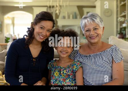 Mixed race woman with her senior mother and her young daughter looking at camera Stock Photo