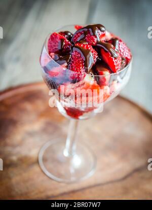 Fresh strawberries under chocolate topping in the glass Stock Photo
