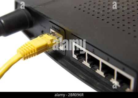 wireless router with yellow internet cable on white background Stock Photo