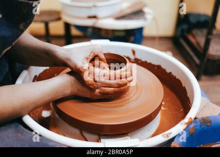 Potter forms a clay jug. Process of creating ceramic products. Woman works on a pottery wheel Stock Photo