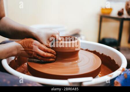 Woman is engaged in pottery. Potter in the process of creating a clay product Stock Photo