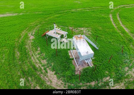 A tank with methanol near the oil well. Equipment of an oil well. Shutoff valves and service equipment. Stock Photo