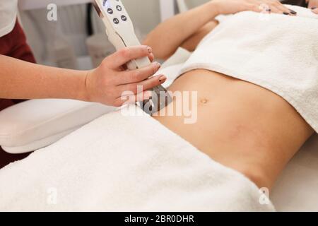 Doctor makes a vacuum massage procedure of the abdomen. Anti- cellulite body correction treatment Stock Photo