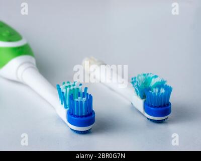 Head electrical toothbrush close up. New and old nozzle electric toothbrushes. Used up electrical toothbrush heads on white background. Copy space Stock Photo
