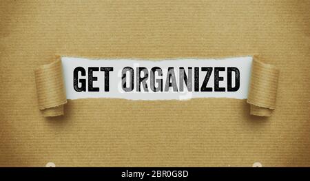 Torn brown paper revealing the words Get organized Stock Photo