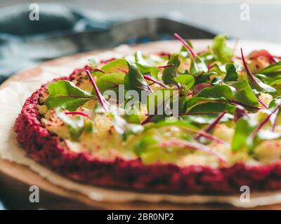 beetroot pizza crust with fresh swiss chard or mangold, beetroot leaves. Ideas and recipes for vegan snack.Egg-free pizza crust with chia seeds and wh Stock Photo