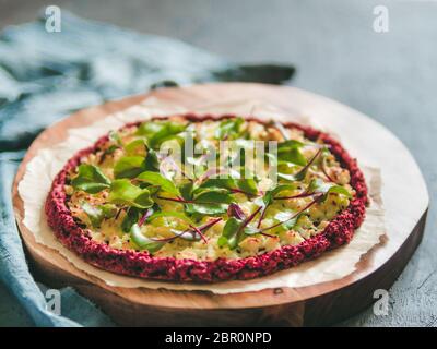 beetroot pizza crust with fresh swiss chard or mangold, beetroot leaves. Ideas and recipes for vegan snack.Egg-free pizza crust with chia seeds and wh Stock Photo