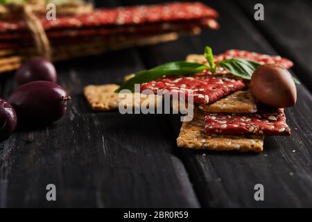 Beetroot and rye flour crackers with vegetables for making snacks on a black background. Vegetarianism and healthy eating. Stock Photo