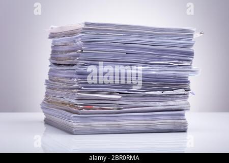 Photo Of Stacked Document Paper On Reflecting Backdrop Stock Photo