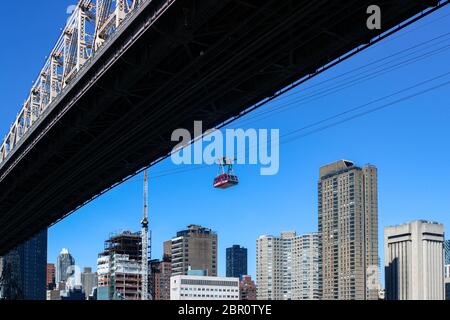 Roosevelt Island Tramway cabin crossing East River next to Ed Koch Queensboro Bridge in New York City, United States of America Stock Photo