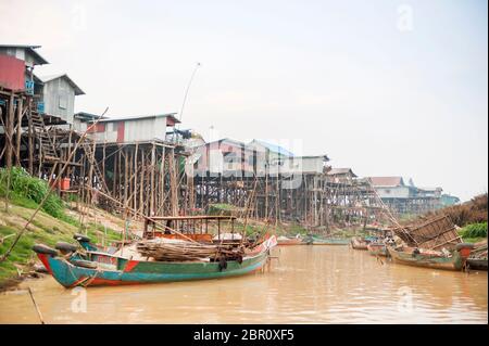 Boats on the river with houses on stilts in the background at Kampong Phluk, Siem Reap Province, Northern-central Cambodia, Southeast Asia Stock Photo