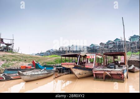 Boats on the river with houses on stilts in the background at Kampong Phluk, Siem Reap Province, Northern-central Cambodia, Southeast Asia Stock Photo