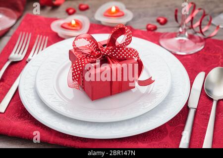 Place setting and gift on holiday table . Stock Photo