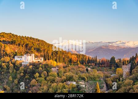 30 November, 2019 - Granada, Spain. View of beautiful Generalife, the garden palace in Alhambra. In the background are the snow capped peaks of the mo