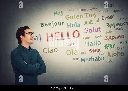 Side view skilled businessman talking different languages. Positive person, student or teacher, wearing glasses, open mouth speaking word hello in mul Stock Photo
