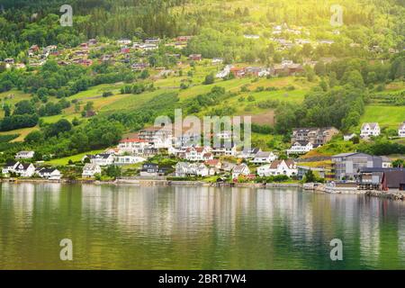 Village houses on mountain slopes. A small village with modern houses by the lake. Environmentally friendly living environment. Stock Photo