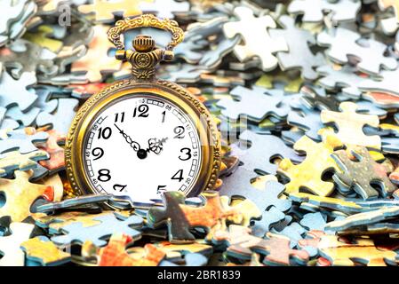Golden clock closeup on separate puzzle pieces background Stock Photo
