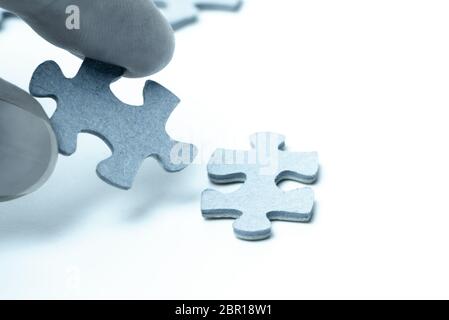 Female hand with puzzle piece on white and blue background Stock Photo