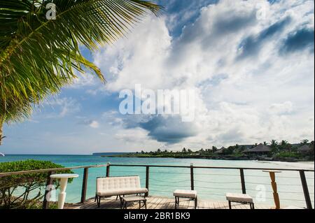 Outdoor restaurant at the beach. Cafe on the beach, ocean and sky. Table setting at tropical beach restaurant. Dominican Republic, Seychelles, Caribbean, Bahamas. Relaxing on remote Paradise beach. Stock Photo