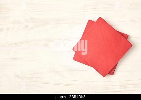 Red tissue paper on wooden table. Top view. Stock Photo