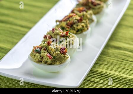 Bacon guacamole deviled eggs Stock Photo