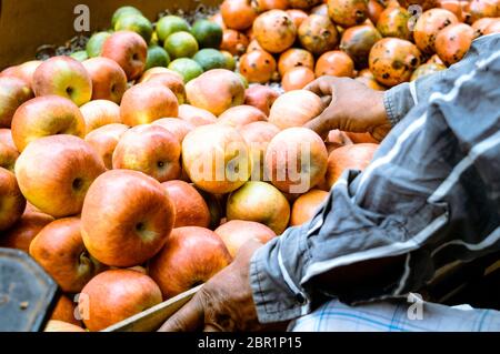 Freshly juicy picked heap of Red apples displayed for customer in a retail shop near roadside, Kolkata, India. Colorful fruit pattern. Business concep Stock Photo