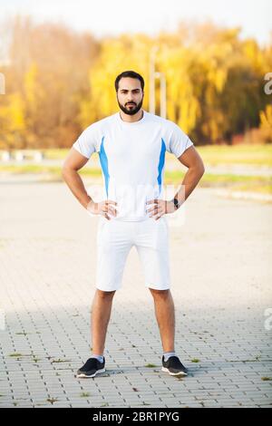 Fitness. Stretch man doing stretching exercise. Standing forward bend stretches of legs Stock Photo