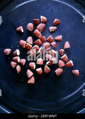 Oven roasting halved almonds for recipe suggestion Stock Photo
