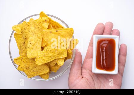 Triangular corn chips, mexican nachos with sauces tomato ketchup, close-up. Stock Photo