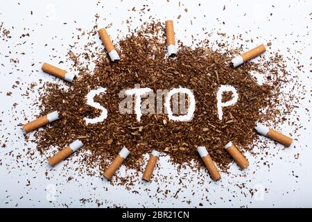 An Elevated View Of Frame Made With Broken Cigarettes Around Stop Word Written On Tobacco Stock Photo