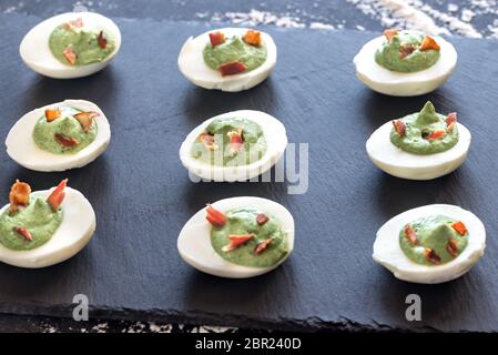 Spinach and bacon deviled eggs Stock Photo