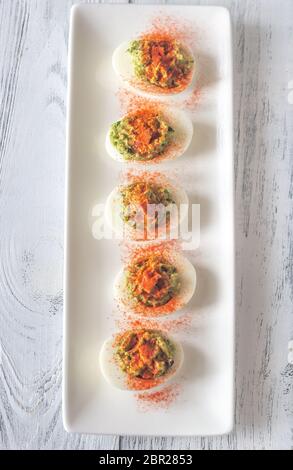 Guacamole and bacon deviled eggs on the white plate Stock Photo
