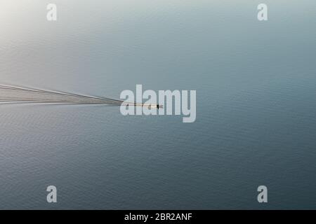 Stunning image of a boat, motor yacht racing through the river in sunlight Stock Photo