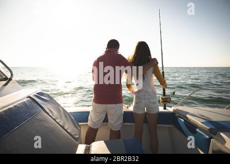 A Caucasian man and his teenage daughter standing on a boat Stock Photo