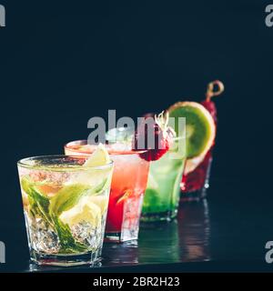 Four colorful tasty alcoholic cocktails in a row at the bar stand. Luxury vacation concept. Place for text. Stock Photo