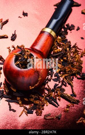 Tobacco pipe with tobacco and scattered virgin tobacco Stock Photo