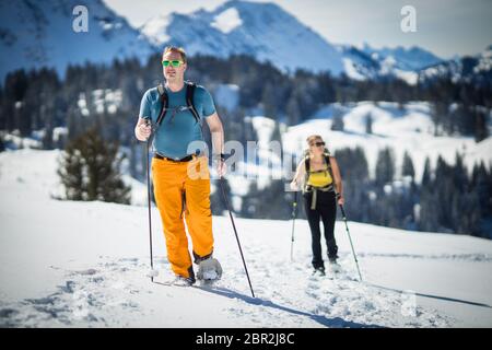 Winter sports - two friends hiking with snowshoes in high mountains Stock Photo
